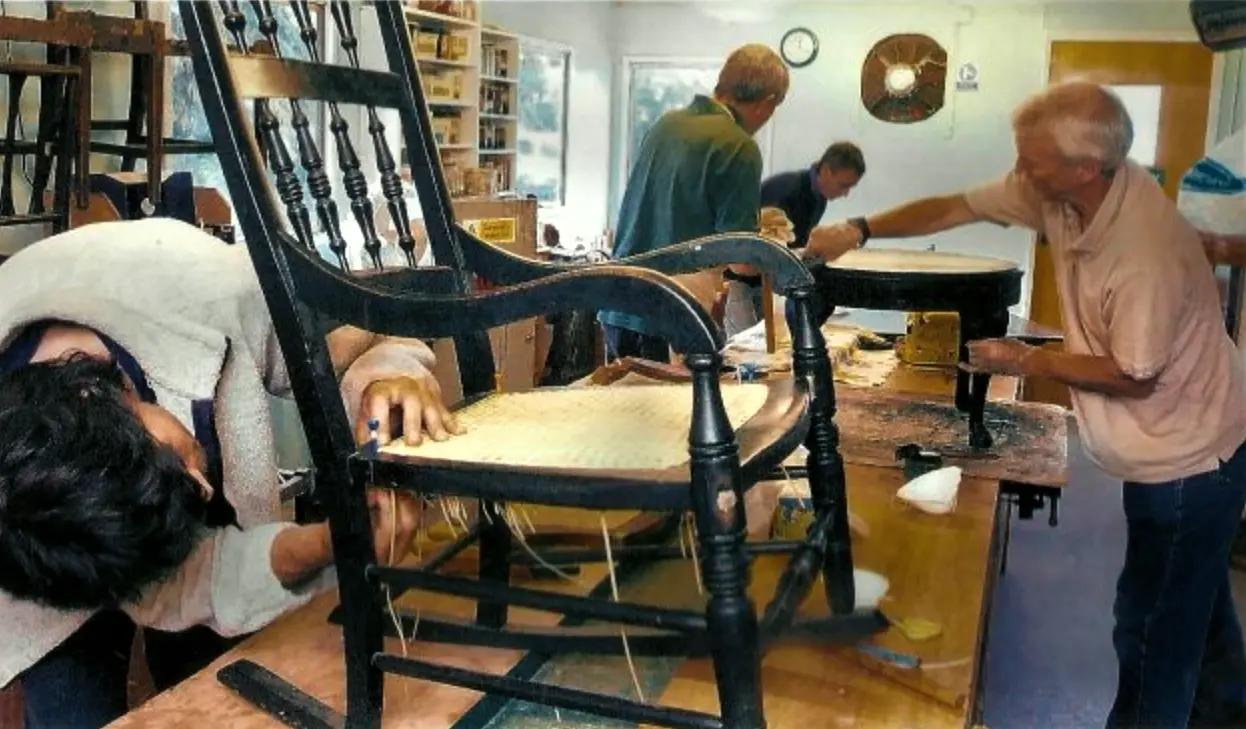 Beneficiaries working on chair weaving and restoration